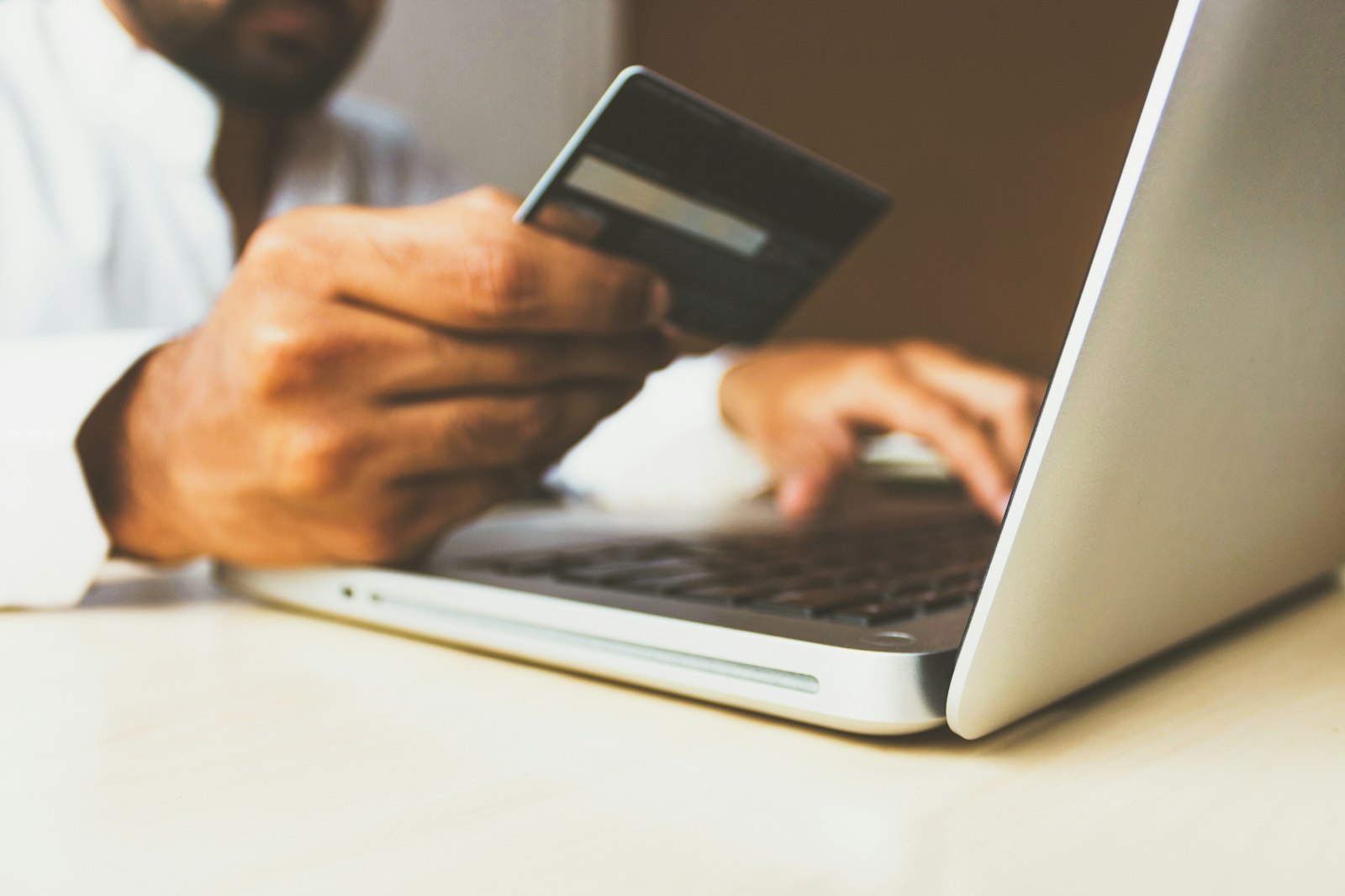 Persona che prenota online con laptop e carta di pagamento