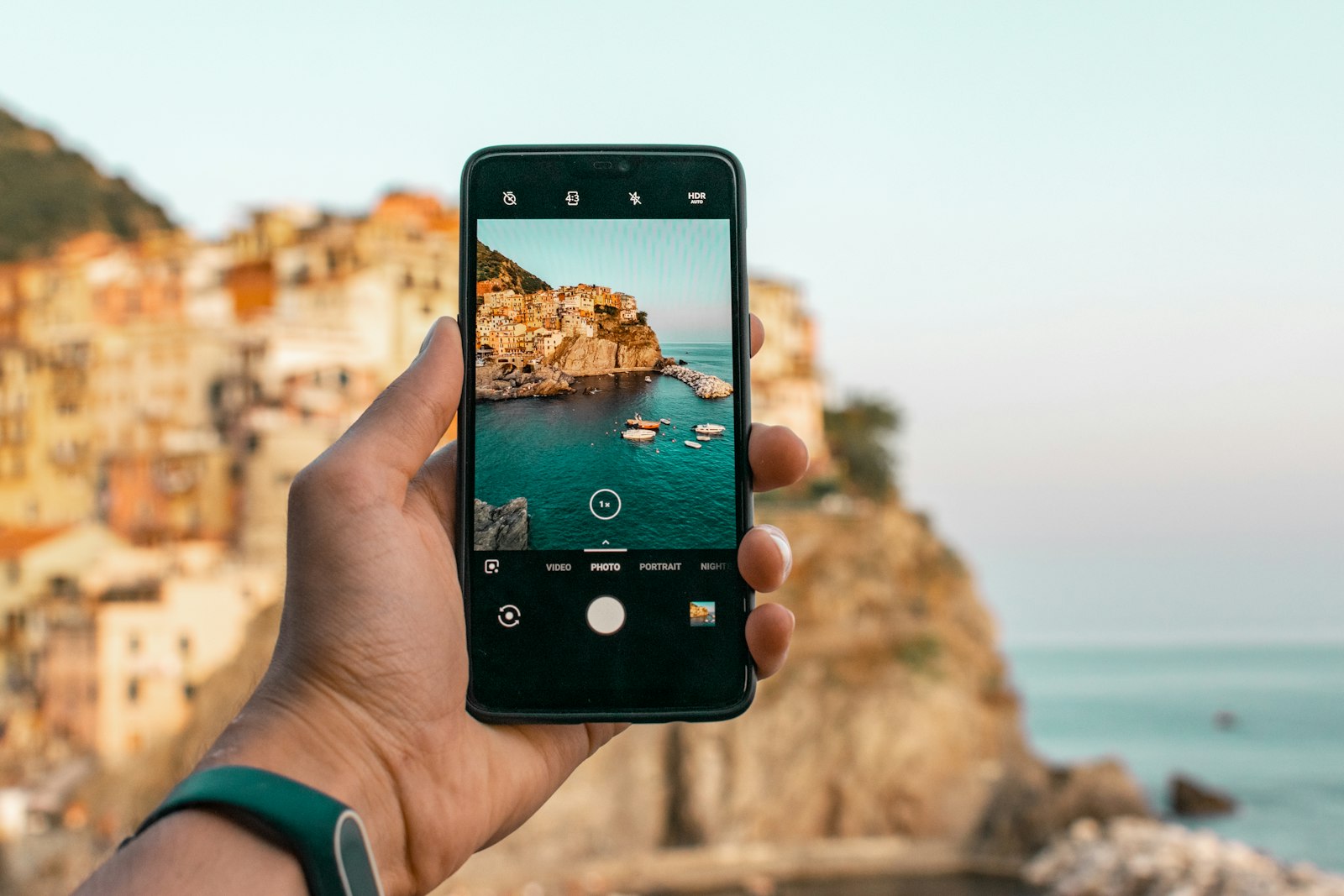 Viaggiatore con lo smartphone in mano affacciato sul mare