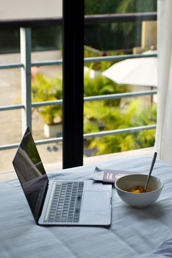 Laptop, passaporto e colazione durante la pianificazione di un viaggio