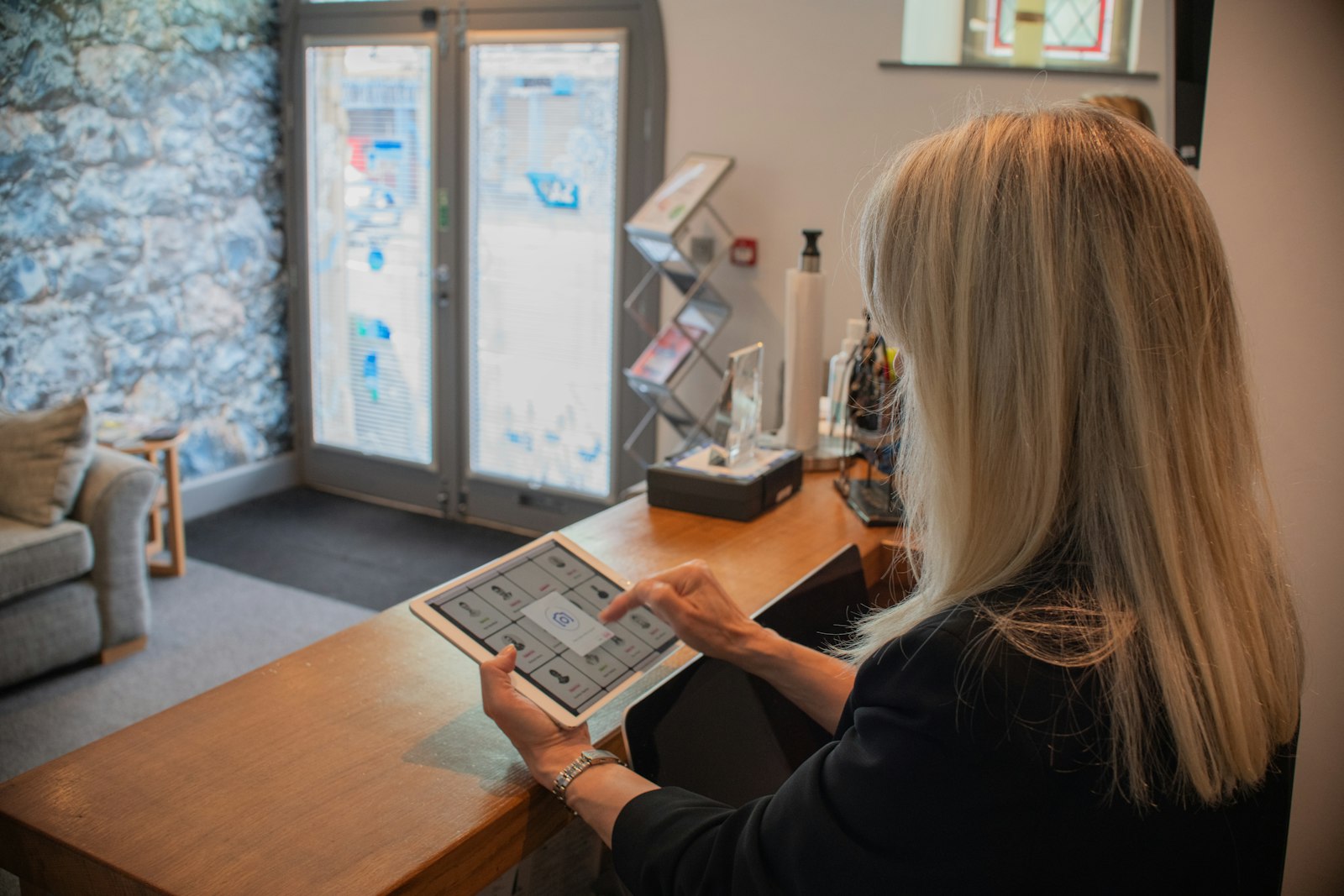 Receptionist using a tablet at a hotel front desk